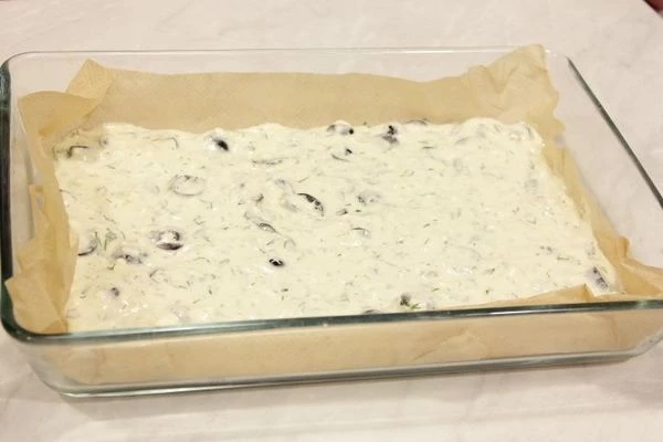 На противень выстелить промасленный пергамент, вылить тесто небольшим слоем.