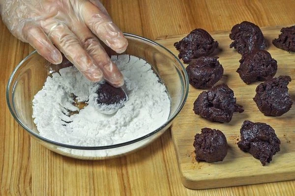 Из холодного теста скатать небольшие шарики, примерно 3 см в диаметре, обвалять в сахарной пудре. 