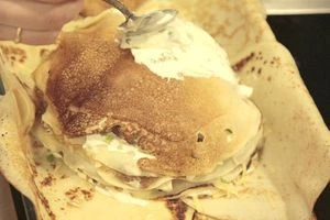 Так чередуем слои, пока блины не закончатся. 4-5 слоев будет достаточно. Последним выкладываем блин, смазываем сыром и сметаной бока, сворачиваем боковые блины так, чтобы получился пирог.