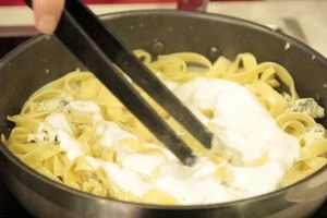 В другой сковороде смешать сливки, бульон, сыр сливочный,сыр с плесенью и моцареллу, нарезанные кубиком. Посолить, поперчить. Как только сыр растворится, добавить пасту и натертый на мелкой терке твердый сыр.