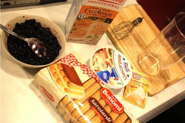 Выложите в небольшие стаканчики палочки Савоярди, предварительно разломав их пополам. Если бокалы для десерта большие и высокие, палочки печенья можно поставить, не разламывая.