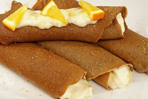 Готовые блинчики смазать с одного края ванильным кремом (примерно 1-2 ст. л.) и завернуть трубочкой. Дать немного постоять.