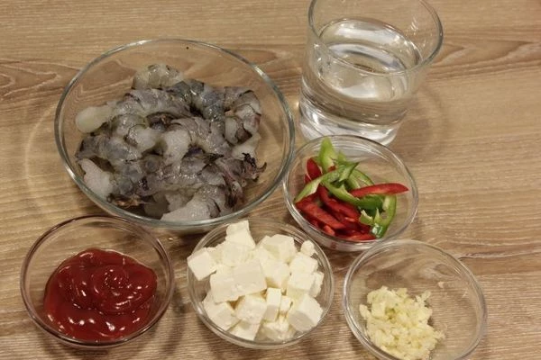 Креветки разморозить естественным способом на нижней полке холодильника. Промыть, очистить от панциря и кишечной нити, обсушить.
Чеснок мелко порубить, перец очистить от семечек и нарезать тонкой соломкой. Помидоры нарезать небольшим кубиком. Кетчуп развести с водой. Петрушку мелко нарезать.