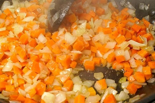 Затем к луку добавить морковь, посолить по вкусу и потушить до золотистого цвета овощей