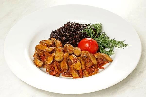 Выложить на тарелку горкой готовый рис рядом тушеные с овощами язычки, украсить свежей зеленью и долькой помидора.