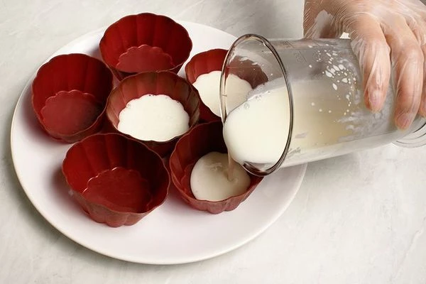 В силиконовые формочки на 1/3 влить молочное желе. Поставить на 5-7 минут застыть в холодильник.