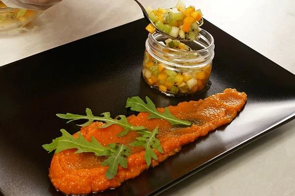 На украшенную морковным пюре и рукколой тарелку выложить фруктовый тар-тар с помощью кондитерского кольца или импровизированной пластиковой формочки.