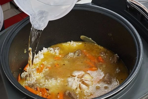 Залить холодной водой в пропорции 2:1. В центр положить головку чеснока. Закрыть мультиварку и поставить режим "Плов". 