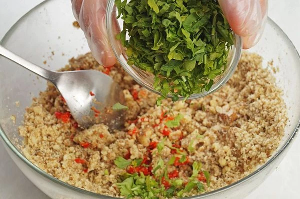 Затем добавить к орехам  перец, винный уксус, нарезанную кинзу, посолить и хорошо перемешать.