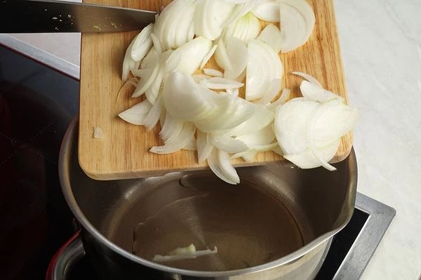 В глубокой кастрюле разогреть растительное масло, обжарить лук до золотистого цвета.