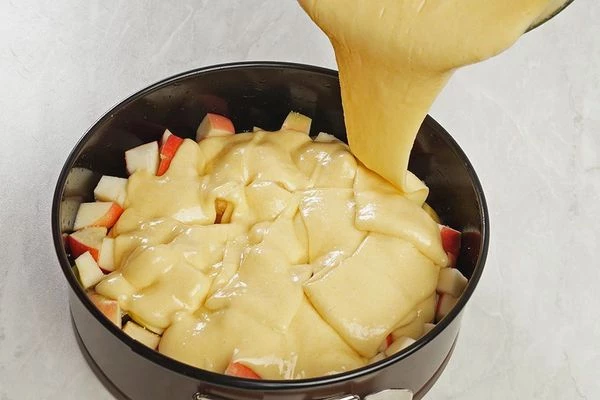 Посыпать яблоки ванильным сахаром, затем залить тестом. Поставить в разогретую до 180С духовку на 20-25 минут.