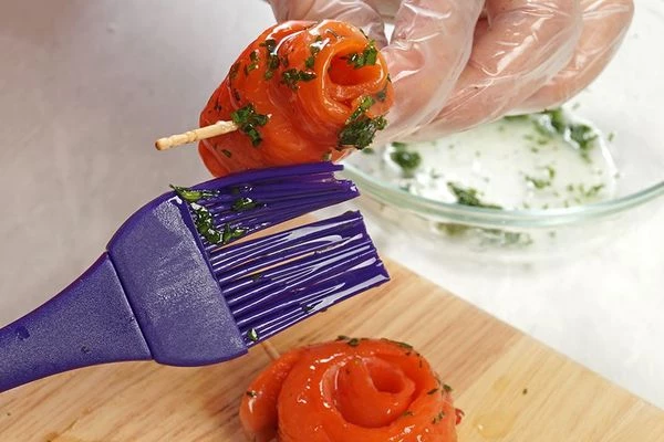 Пока суп готовится, из филе рыбы нарезать полоски, толщиной 2-3мм, свернуть рулетиками, скрепить с одной стороны зубочисткой. Смазать растительным маслом.