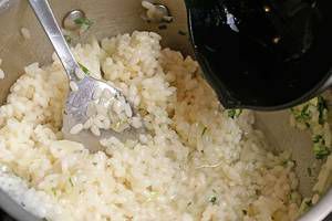  Выпаривать рис с бульоном порциями, пока  рис не дойдет до состояния "аль денте". т.е слегка твердым внутри. Добавить порубленную петрушку, снять с огня