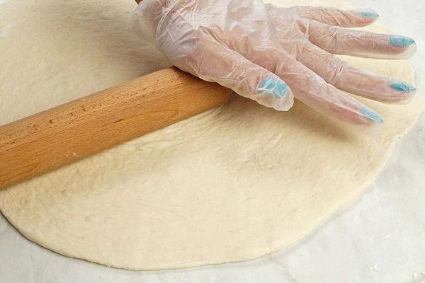Раскатайте тесто с помощью скалки (можно растянуть тесто руками нужного диаметра). Переложите на противень, застеленный пергаментной бумагой.