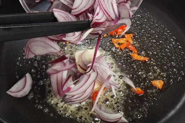 Затем добавить нарезанный тонкой соломкой лук, обжарить до мягкости.