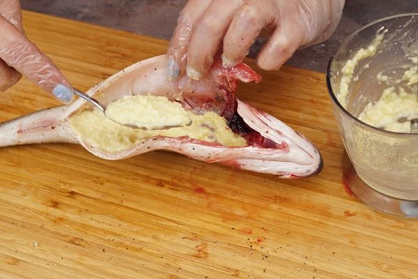 Получившуюся заправку выложить в брюшко рыбы.