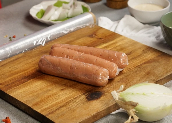 Пленку с фаршем свернуть в форме сосиски, завязать края. Повторить со всем фаршем и сыром.