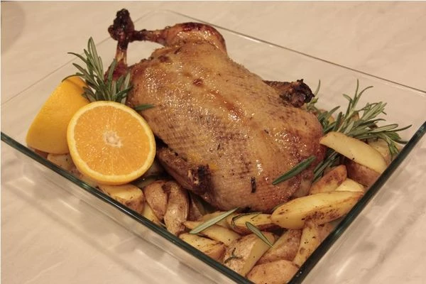 Укладывайте утку в середину тарелки с гарниром. Предварительно удалите нитки и зубочистки. Содержимое брюшка можно вынуть и выложить горкой рядом с уткой, а можно оставить внутри.