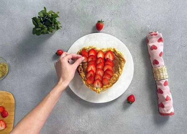 Затем остудить до комнатной температуры. Оформить нарезанной клубникой.