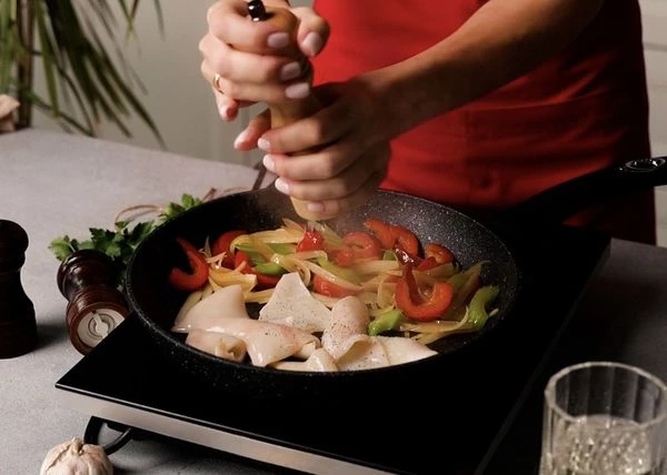 Когда вода выкипит добавить нарезанные кальмары, жарить около 1 минуты. Влить белое вино, выпарить на высоком огне на ⅔. Кальмаров в общей сложности готовить 2-3 минуты, иначе они станут жесткими.  Посолить и поперчить. 