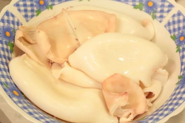 Кальмара разморозить естественным путем на нижней полке холодильника на дренаже. Очистить, промыть.