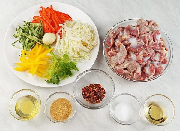 Желудки разморозить естественным способом на нижней полке холодильника, зачистить, промыть. Отварить в кипящей подсоленной воде до готовности. Овощи нарезать тонкой соломкой.