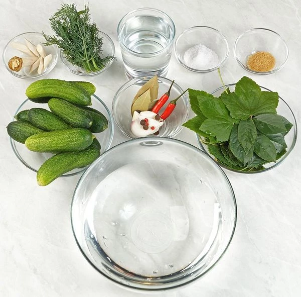 Подготовить необходимые ингредиенты. Огурцы тщательно промыть, отсортировать по размеру. Листья вишни, смородины, хрена промыть.