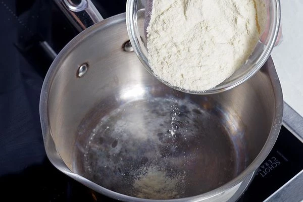 Обжарить в сухой кастрюле муку, постоянно помешивая, до легкого изменения цвета и орехового аромата.