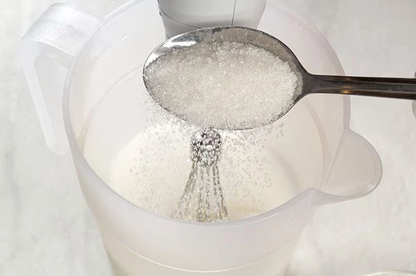 Не переставая взбивать, добавить порциями сахар (120 г).