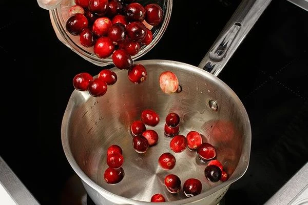 Пока запекается рулет, приготовить соус из клюквы.