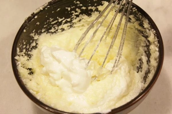  Масло сливочное растереть с сахаром до бела. Не переставая растирать, добавляем сметану по 1 ст.л за раз.Довести до полного растворения сахара.