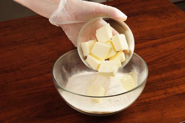 В глубокой чашке смешать муку и сливочное масло.