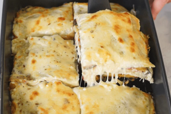 Поставить лазанью в предварительно разогретую до 200 градусов духовку, запекать в течение 20 минут.
Готовую лазанью порезать на порционные кусочки.