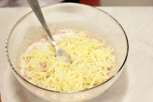 Добавить в получившуюся смесь муку с разрыхлителем, масло, натертый сыр.