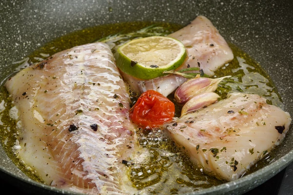 На отдельной сковороде обжарить на слабом огне треску вместе с маринадом (получается эффект паширования в масле на низкой температуре).