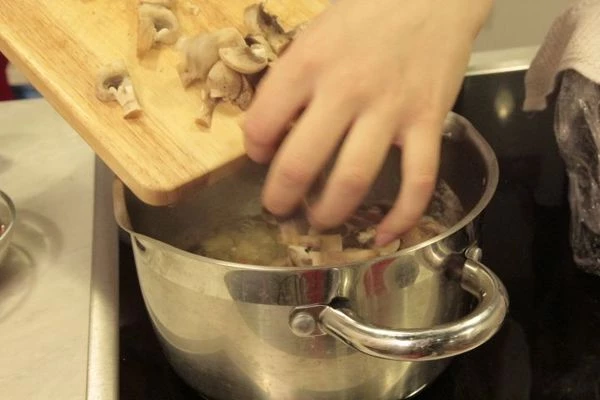 Заранее сваренный овощной бульон довести до кипения, опустить туда картофель. Варить до полуготовности. Затем добавить грибы и обжаренные овощи. Посолить, поперчить по вкусу. Проварить 5-7 минут.