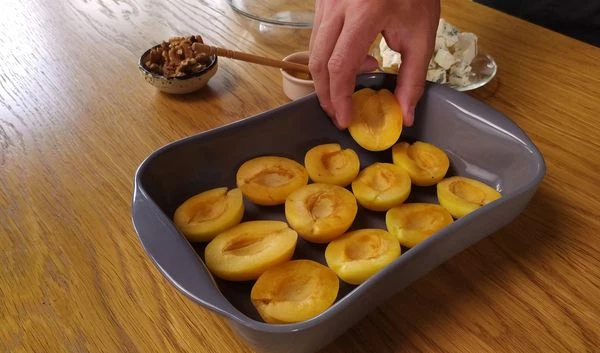 Абрикосы вымыть, разрезать пополам. Выложить в форму для запекания.