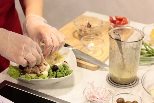 Выложить в тарелку смесь салатов, немного полить заправкой, затем выложить нарезанный произвольно картофель, фасоль, половинки помидоров и перепелиных яиц, шалот соломкой, тунец.