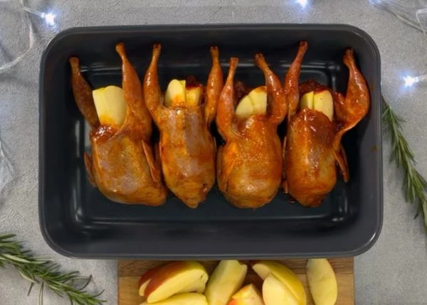 Нафаршировать перепелов яблоками, выложить в емкость для запекания.