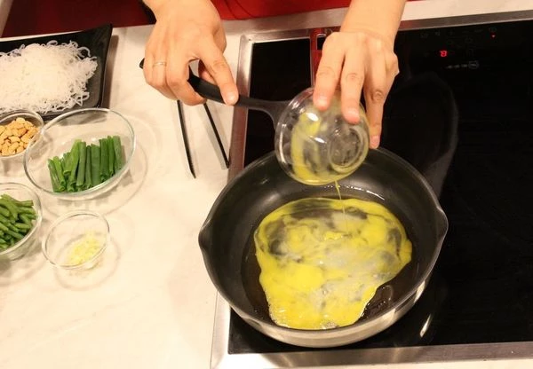 На разогретой с оливковым маслом сковороде обжарьте 2 яйца в течение 2 минут, посолите, поперчите по вкусу, отодвиньте на край сковороды.