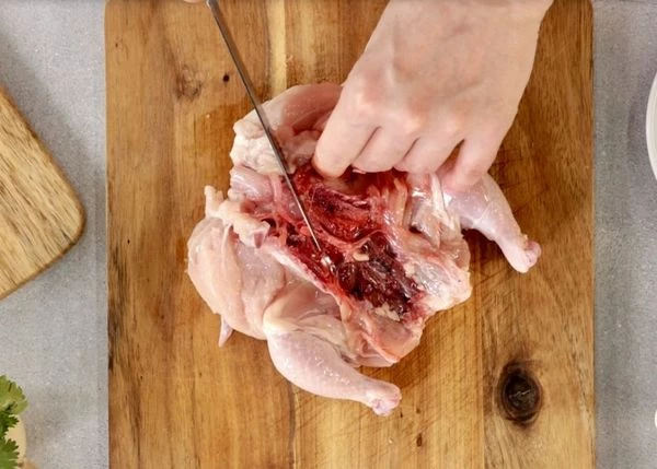 Цыпленка разморозить на нижней полке холодильника, промыть водой. Прорезать грудку насквозь, удалить лишнюю кожу. Удалить килевую кость. 