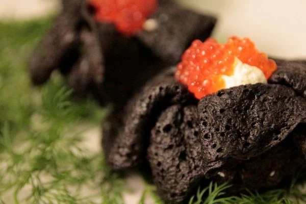 Готовые блинчики остудить. В центр выложить горкой сливочный сыр, завернуть в виде мешочка, перевязав пером зеленого лука. Украсить красной икрой.