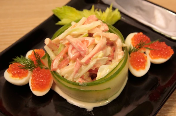 Огурцы нарезать тонкими пластинками с помощью овощечистки и замочить в холодной воде.