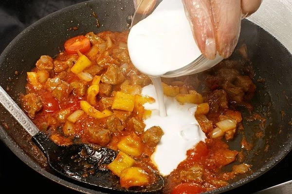 Влить кокосовое молоко, довести до вкуса солью, перцем. Тушить до готовности мяса.