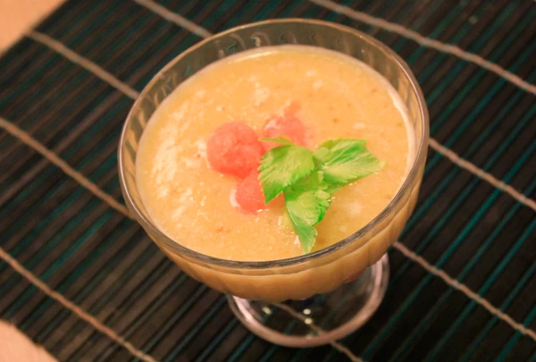 В десертную вазочку выложить пюре из белого персика, не размораживая, на него пудинг из тапиоки, украсить шариками из замороженного пюре.