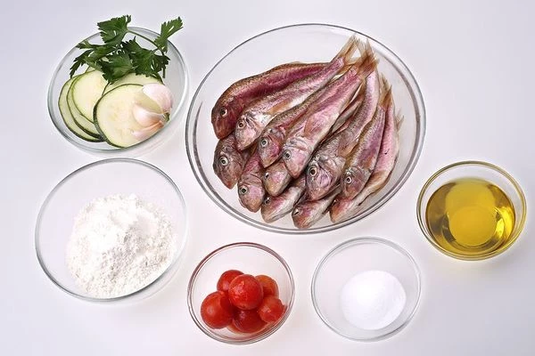 Барабульку разморозить естественным способом на нижней полке холодильника. Почистить от чешуи, разрезать вдоль брюшка и удалить внутренности. Подготовить кабачки: промыть под проточной водой, нарезать тонкими пластиками (кружочками)