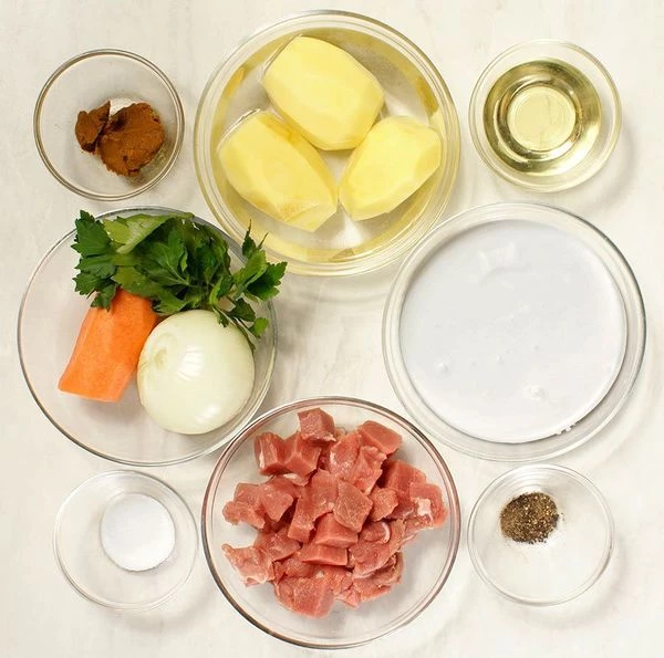 Свинину разморозить естественным способом на нижней полке холодильника. Нарезать небольшим кубиком. Картофель, морковь и лук очистить.