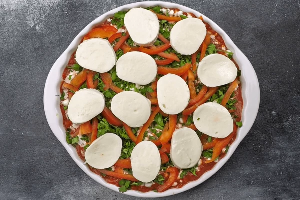 Сверху выложить нарезанную кружочками моцареллу и поставить запекать в разогретую до 180С духовку на 25-30 минут. 