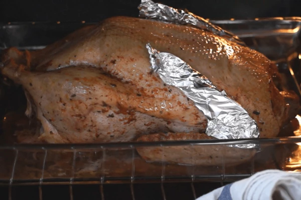 Поставить в разогретую до 150 градусов духовку на 1,5 часа. При низкой температуре запекания утка останется сочной. Затем накрыть фольгой всю тушку и запекать 1 час при 180 градусах.
