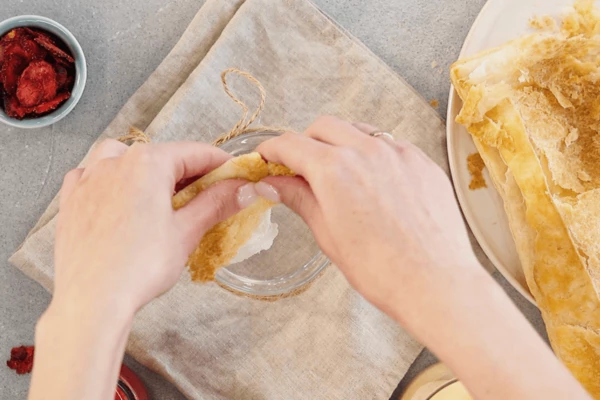 В подготовленную посуду (банку) раскрошить тесто. 